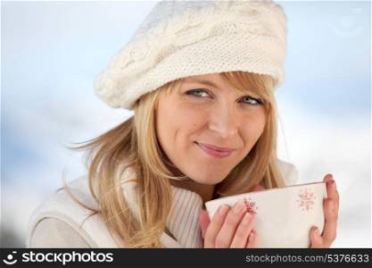 Woman keeping warn by drinking bowl of hot chocolate