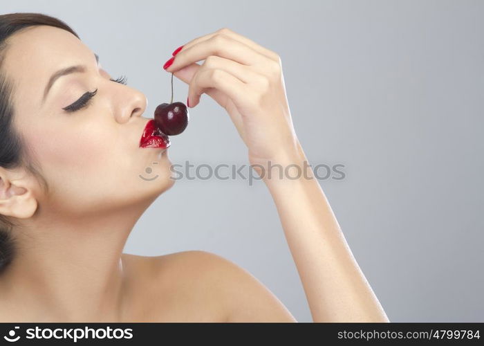 Woman kissing a cherry