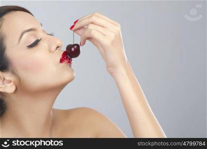 Woman kissing a cherry