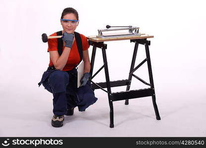 Woman kneeling beside her workbench