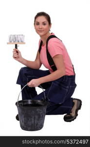 Woman kneeling by bucket of wall paper paste