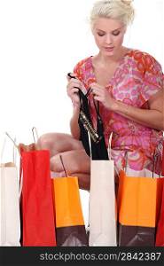 Woman kneeling by shopping back full of lingerie