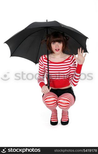 Woman kneeling with umbrella
