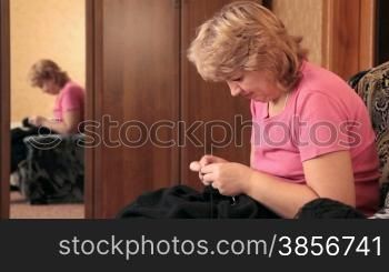 Woman knitting a sweater.