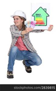 Woman laborer holding energy rating sign and bills