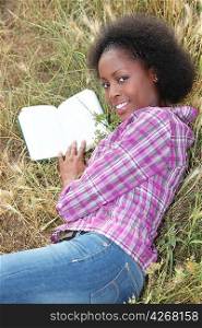 Woman laid in field reading book