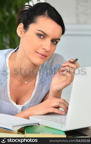 Woman laid on a sofa using laptop