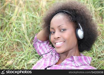 Woman laid on grass listening to music