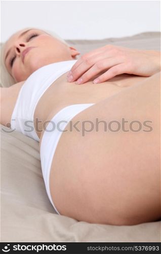 Woman laid on her bed in underwear