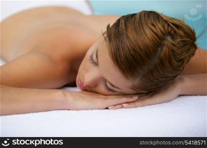 Woman laid on massage table with eyes closed