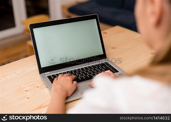 woman laptop computer smartphone mug office supplies technological devices. Young lady using a laptop with both hands on the computer. Left hand on the black keyboard and the other on the touchpad. Office supplies, technological devices and wooden desk.