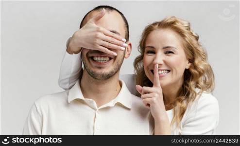 woman laughing covers man eyes