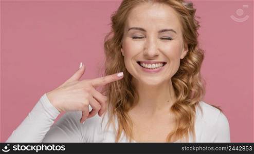 woman laughing pointing her smile