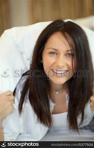 Woman laughing under a duvet