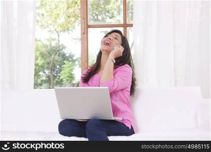 Woman laughing while talking on mobile phone