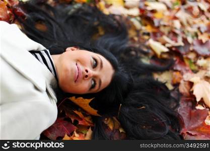 woman lay on yellow autumn leaves