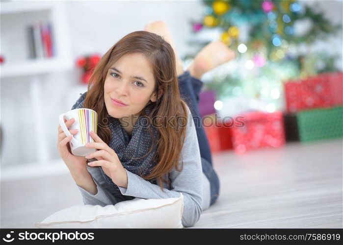 woman layed on floor with a mug of drink