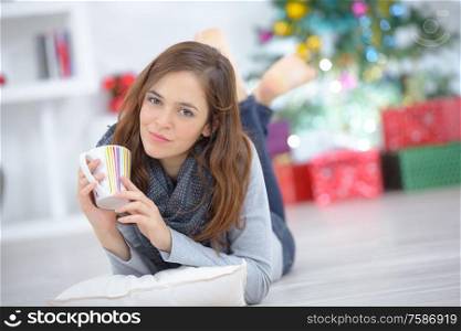 woman layed on floor with a mug of drink