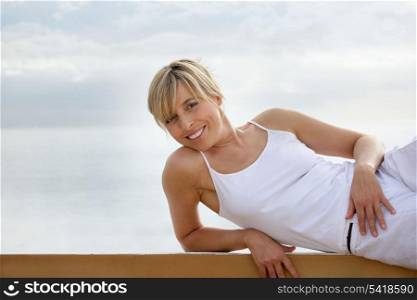 Woman laying at wall at the beach