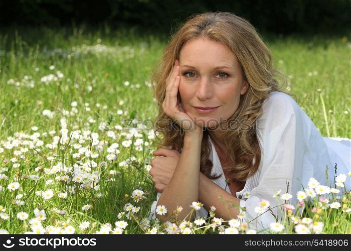 Woman laying down in field full of flowers