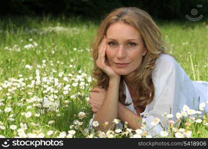 Woman laying down in field full of flowers