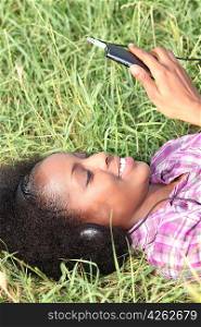 Woman laying in park listening to music