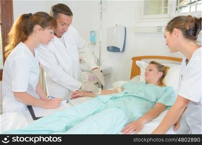 woman laying on a hospital bed and doctors around her