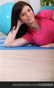 Woman laying on gym mat