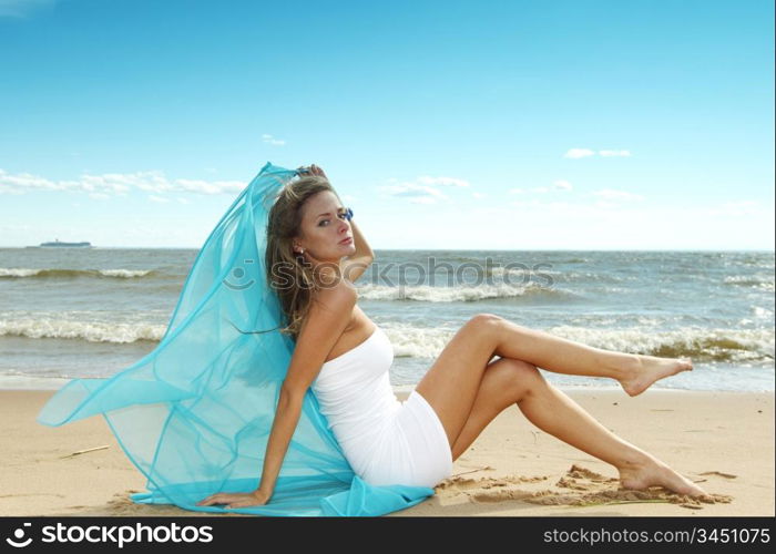 woman laying on sand sea on background