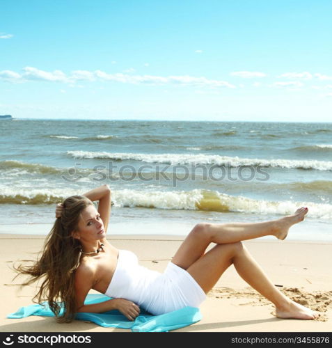 woman laying on sand sea on background