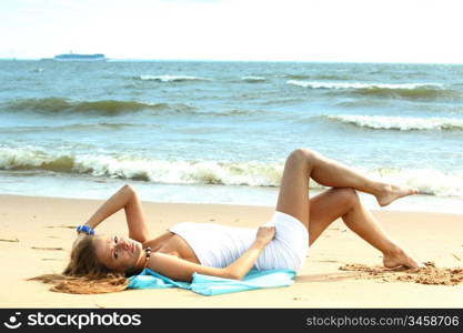 woman laying on sand sea on background