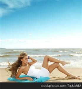 woman laying on sand sea on background