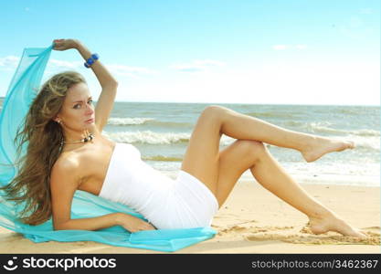 woman laying on sand sea on background