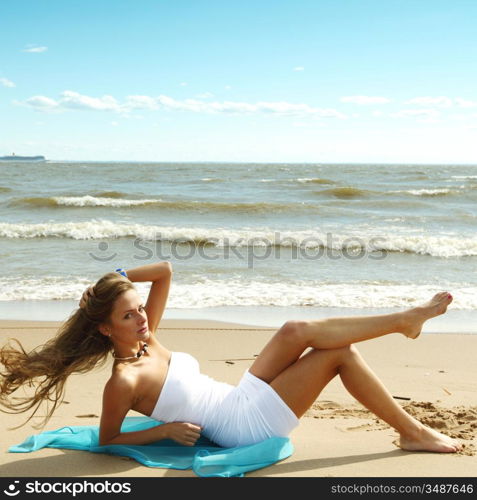 woman laying on sand sea on background