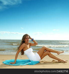 woman laying on sand sea on background