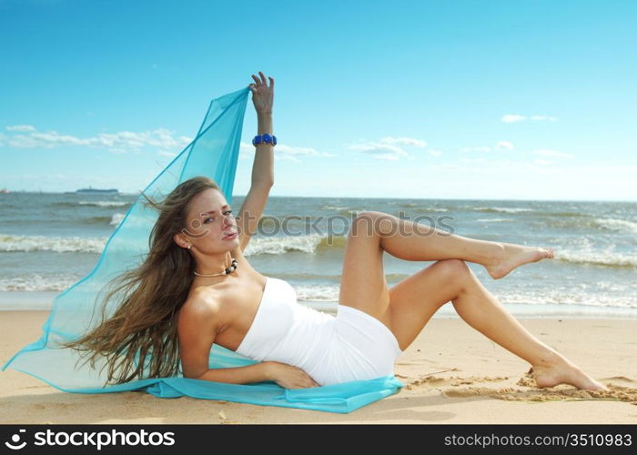 woman laying on sand sea on background