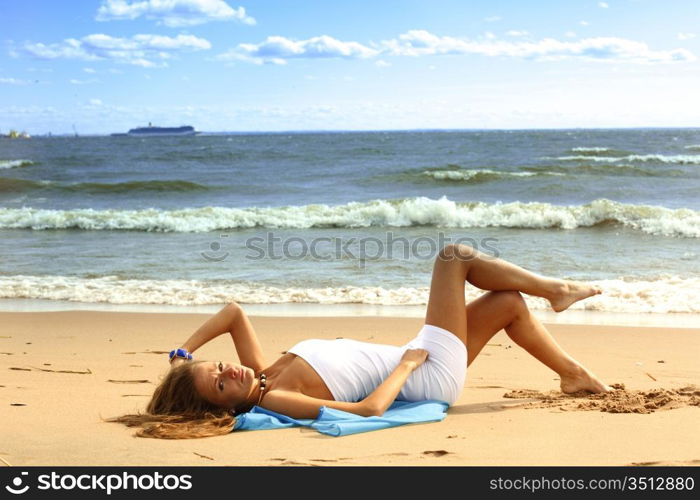 woman laying on sand sea on background