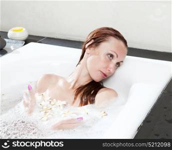 woman lays in soapsuds in bathing, full water