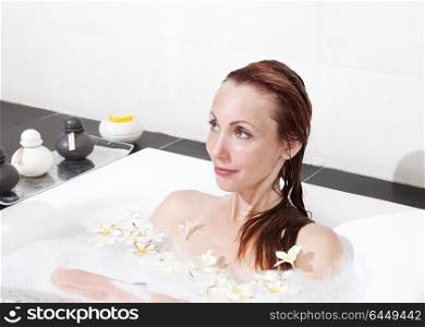 woman lays in soapsuds in bathing, full water