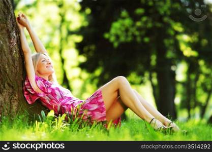 Woman leaning against a tree