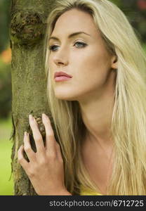 woman leaning against tree