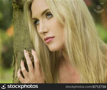 woman leaning against tree