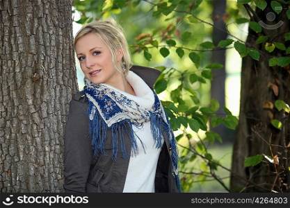 Woman leaning against tree trunk