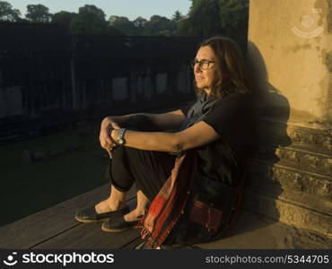 Woman leaning against wall of temple, Krong Siem Reap, Siem Reap, Cambodia