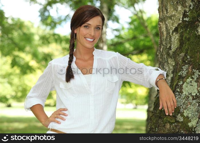 Woman leaning on a tree