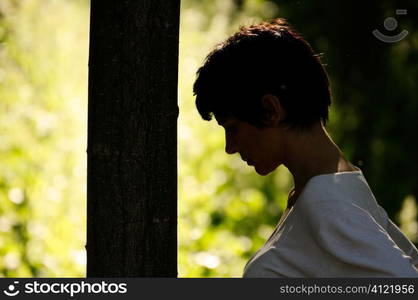 Woman leaning on a tree