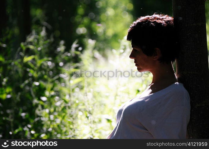 Woman leaning on a tree