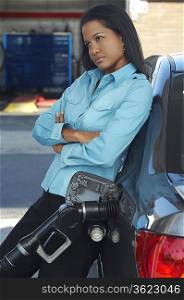 Woman leaning on car with gas pump in it