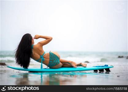 Woman Leaning On Surfboard At Beach Against Sky