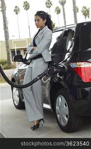 Woman leaning on van with fuel pump in it